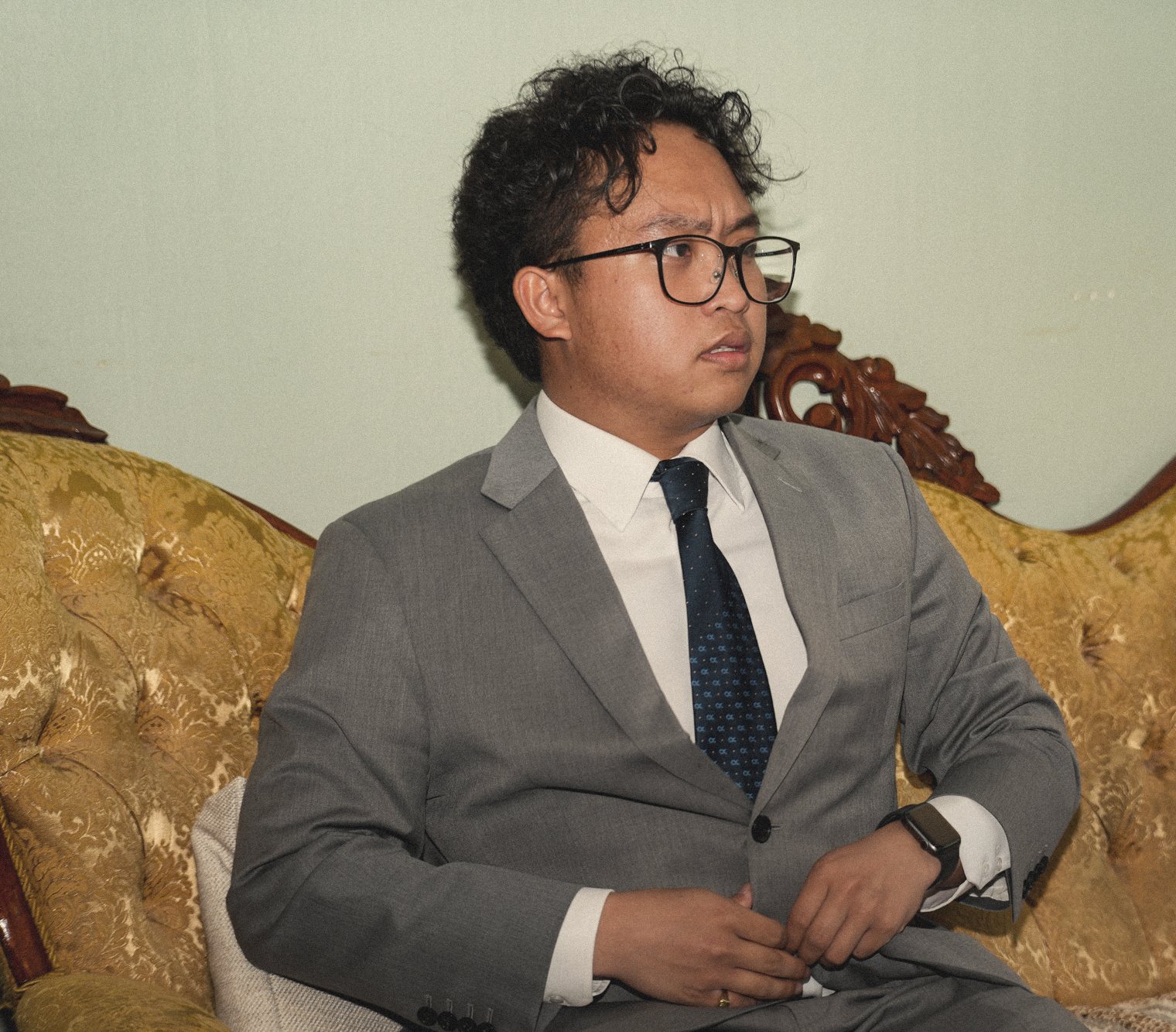 A young man in a dark suit at a graduation celebration